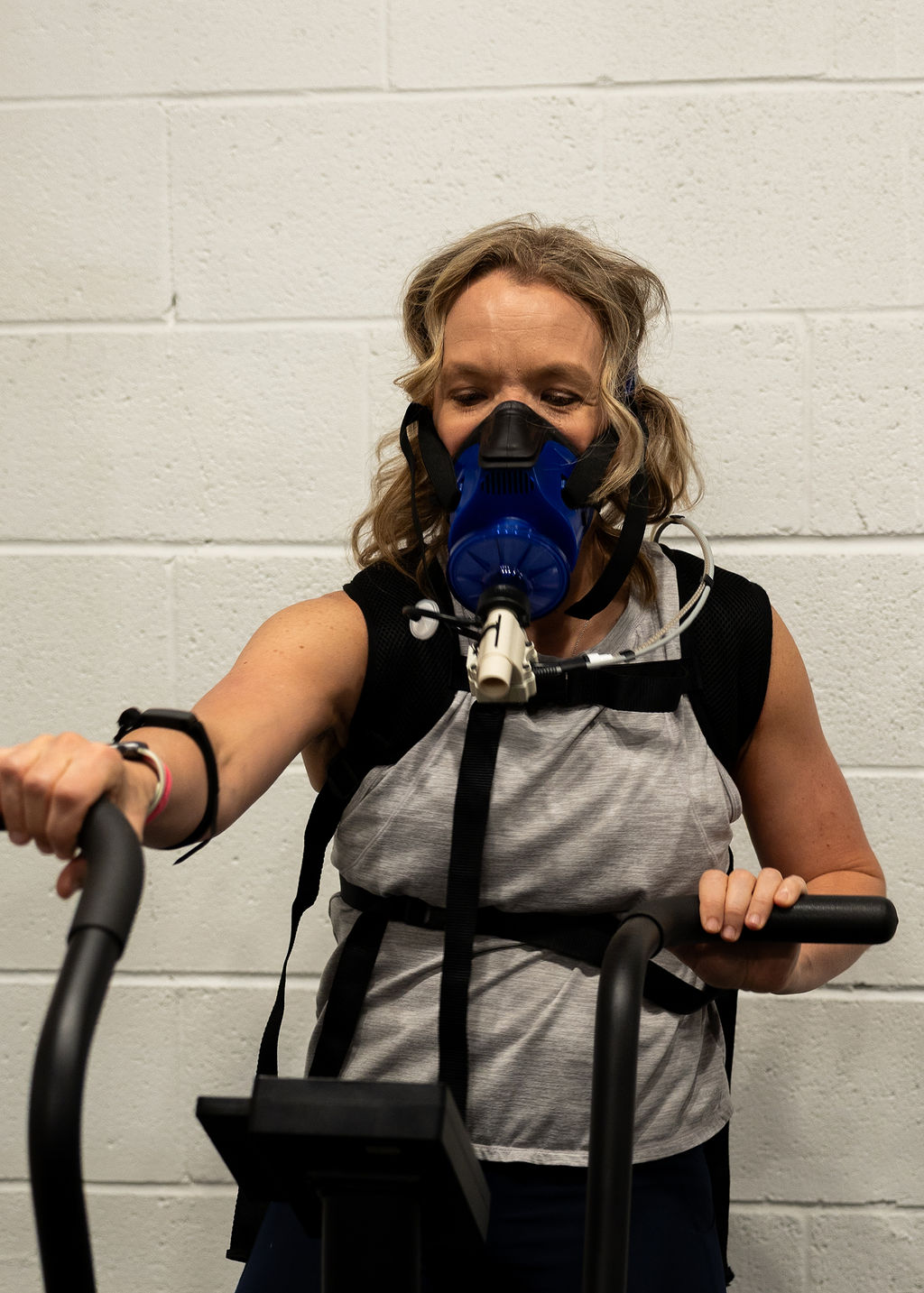 Client on a bike wearing the PNOĒ breathing mask