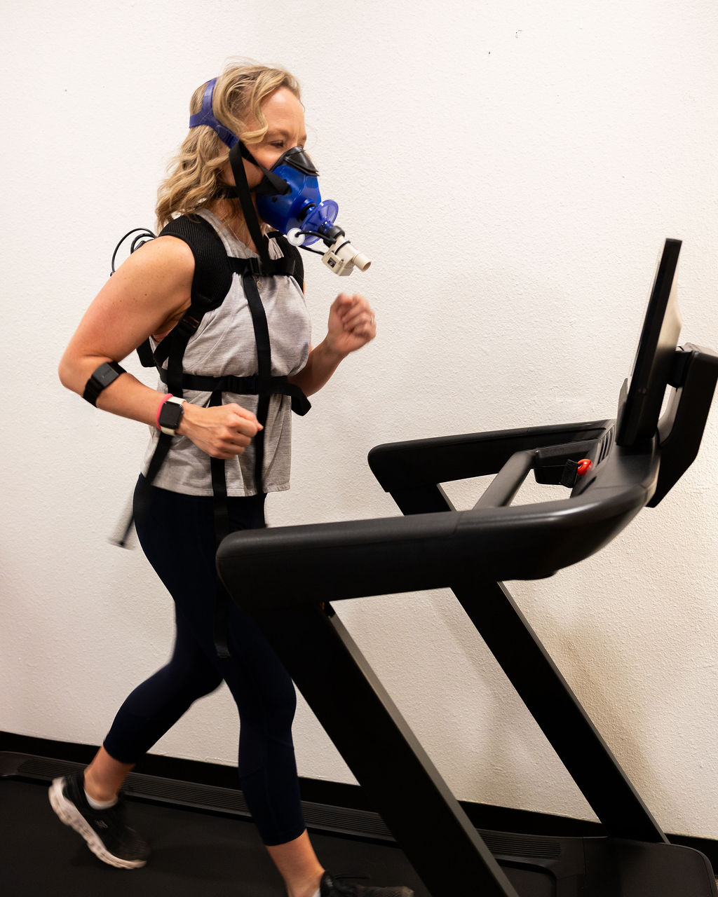 Client running on a treadmill wearing a breath-analysis mask during a VO₂ max test